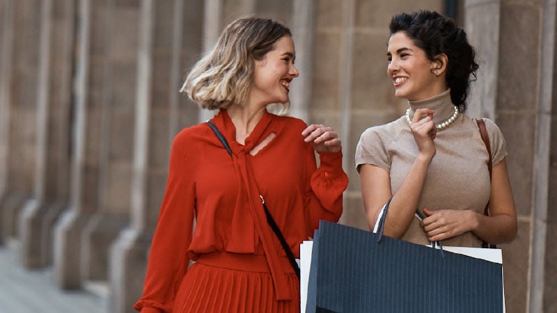 Two women going along the street with shopping bags