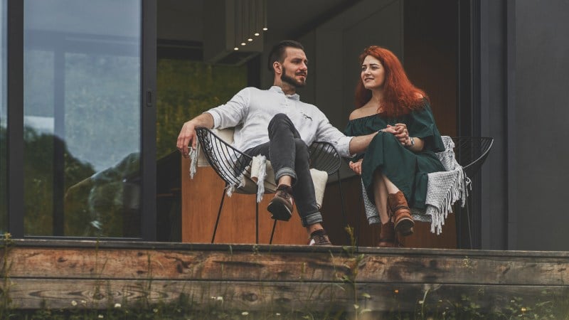 A man and a woman sitting in armchairs on a terrace